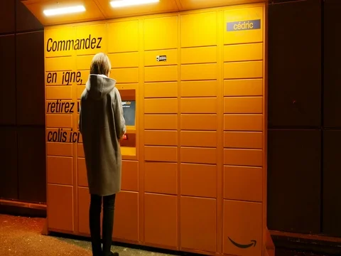 Woman taking parcel from Amazon Locker the self-service parcel delivery service Stock Footage 72719919