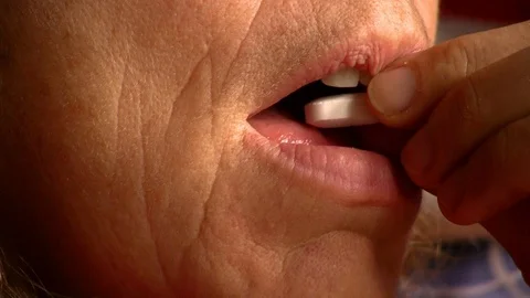 Woman taking a pill while drinking a glass of water Video stock 104661562