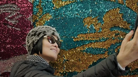 Woman taking selfie in front of glitter art. Stock Footage 99669727
