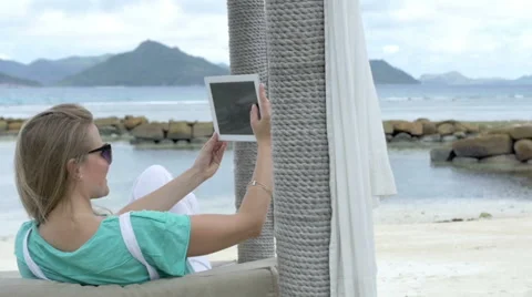Woman taking selfie with tablet while enjoying vacation in tropical resort. Stock Footage 52480555