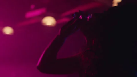 Woman taking shot while sitting in pink light Stock Footage 275123359