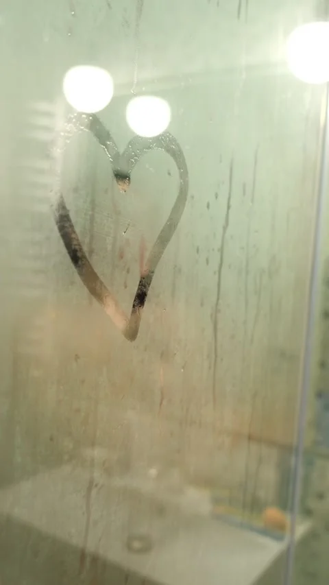 Woman taking shower view through misty glass Stock Footage