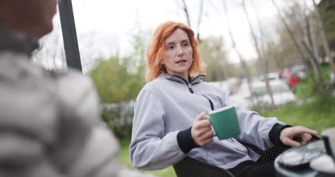 Woman talking to man over Coffee outside on a Spring morning in the Park, man Stock Footage 338366455