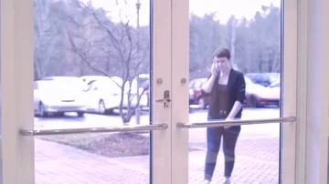 Woman talking on the phone and entering the building Stock Footage