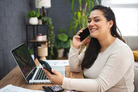 Woman talking on the phone while doing home finances Stock Photos