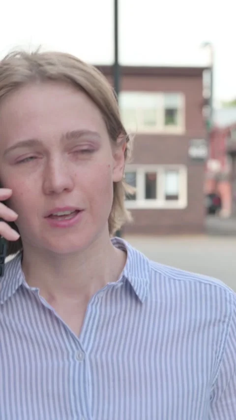 Woman Talking on Phone while Walking in Street, Vertical Video Stock Footage 339669300