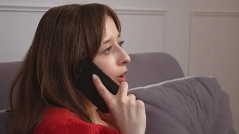 Woman talking on smartphone while relaxing on sofa 库存影片 313298647