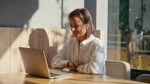 A woman is talking with someone using her laptop computer and video connection Stock Footage 228258634
