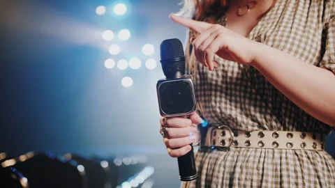 Woman Tapping Microphone with Finger to Test Sound on Theater Stage 動画素材 337825613