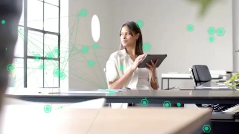 Woman tapping tablet looking right in office, causing green node overlay over Stock Footage 333369090