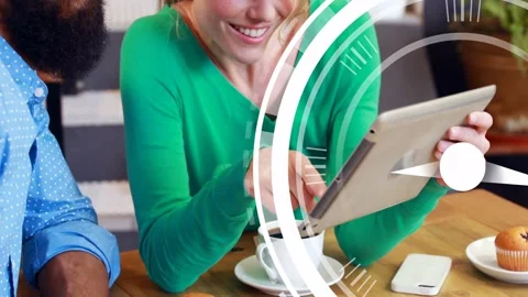 Woman tapping tablet man leaning at cafe viewing tech demo while clock graphic Stock Footage 333132437