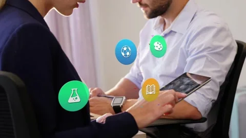 Woman tapping tablet, man observing, spawning colorful tech icons grouping near Stock Footage 335739947