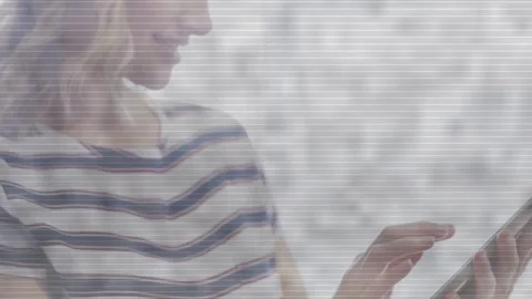 Woman tapping tablet screen in bright room, activating animated UI elements for Stock Footage 333463343