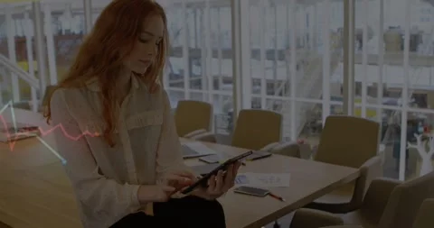 Woman tapping tablet screen, causing animated red green line graph overlay Stock Footage 317740547