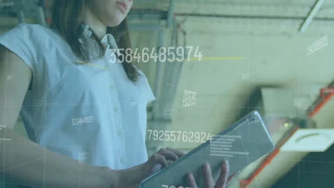 Woman tapping tablet screen, scrolling to review data with codes, grid lines in Stock Footage 311097948