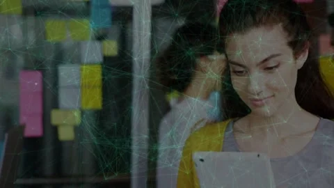 Woman tapping tablet scrolling, creating network overlay linking to Post-its for Stock Footage 333540000