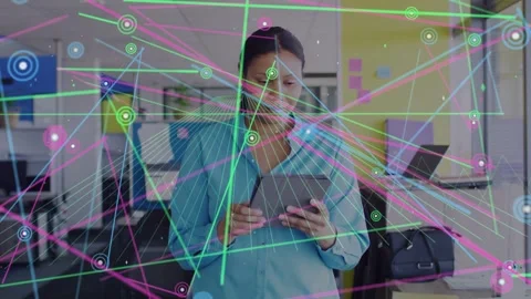Woman tapping tablet in tech office activating nodes and lines expanding over Stock Footage 333873486