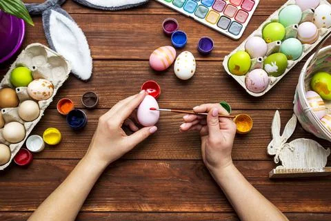 A woman with a tassel paints Easter eggs. Preparing decorations for Easter, c Stock Photos