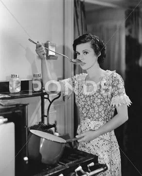 Woman tasting food cooking on stove Stock Photos