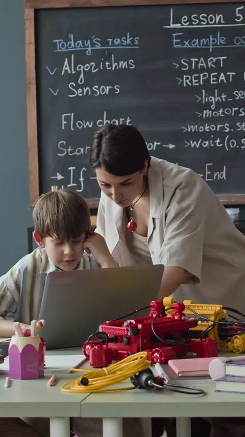 Woman Teacher and Schoolboy Coding Robot with Laptop in Stem Class Stock Footage 339192044