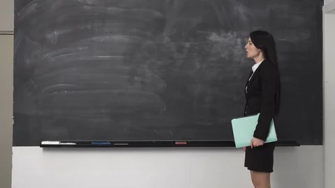 Woman teacher explaining something at clean blackboard Stock Footage 77162096