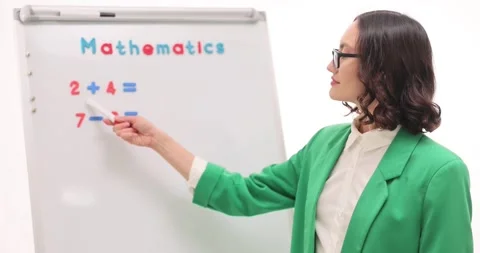 Woman teacher explains math exercise on whiteboard at lesson Stock Footage 289238133