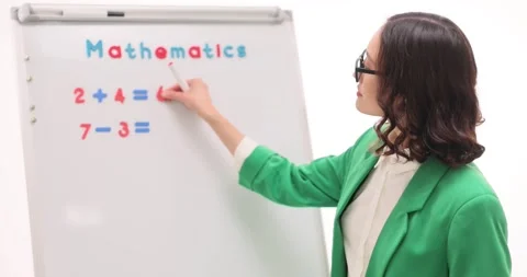 Woman teacher explains maths problems on whiteboard at lesson Stock Footage 292998170