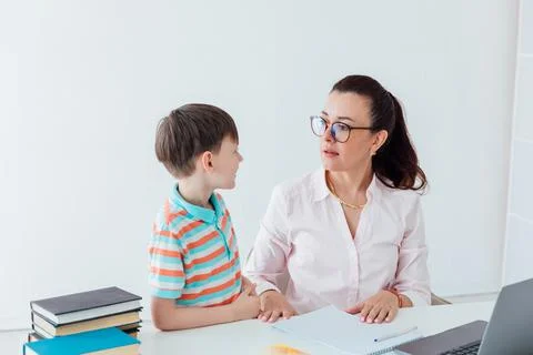 Woman teaching boy to work on computer online Foto stock