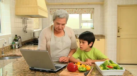 Woman teaching grandson how to cook Stock Footage