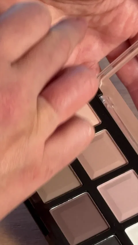 A woman is testing different shades from a makeup palette. Close-up. Vertic.. 库存影片 302104708