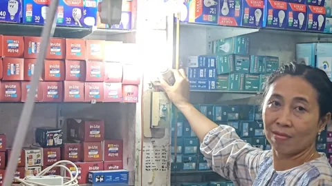 Woman Testing LED Light Bulb In Electrical Shop Stock Footage 332196199