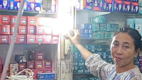 Woman Testing LED Light Bulb In Electrical Shop Stock Footage 332196202