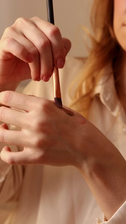 Woman testing makeup swatch on hand with brush Stock Footage 329613273