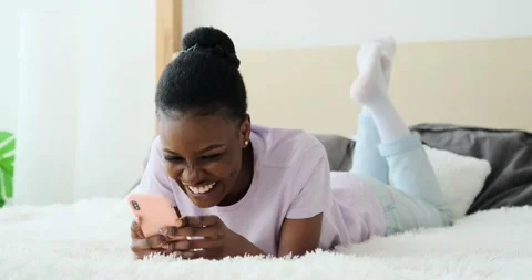 Woman text messaging using mobile phone on bed 動画素材 155111902