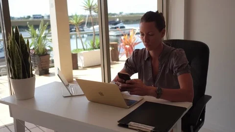 Woman texting in front of computer Stock Footage 88149029