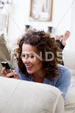 Woman Texting On Her Handy, Laying