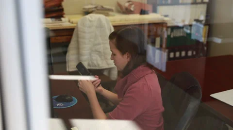 A woman texting on phone while at work Stock Footage 32790632
