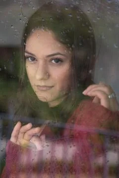 Woman, thinking about something while looking out the window on a rainy day. 写真素材