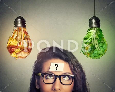 Woman Thinking Looking At Junk Food And Vegetables Shaped As Light Bulb