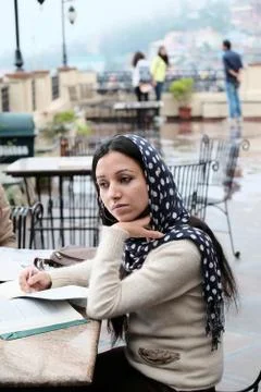 Woman thinking while studying in a cafe. Stock Photos