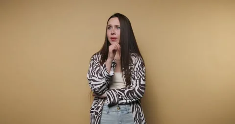 Woman thinks deeply while posing against yellow wall at indoor location dur.. Stock-Footage 331990023