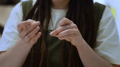 Woman threading a needle in sewing studio workshop Vidéo 336247616