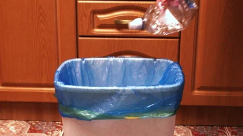 Woman throwing garbage into trash bin in kitchen Stock Footage 327861277