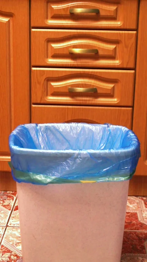 Woman throwing garbage into trash bin in kitchen Stock Footage 328370600