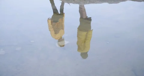 Woman throwing pebble at reflection on stable water Stock Footage 85963217