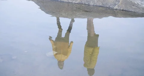 Woman throwing pebble at reflection on stable water Stock-Footage 85963235