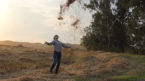Woman throws up a bundle of straw. Slow motion. Video stock 137147131