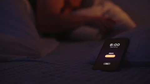 Woman Throws Pillow Toward Ringing Smartphone Alarm at 6 AM While Lying in Bed Stock Footage 305290946