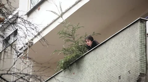 Woman Throws a Tree off Balcony Stock Footage 13359482