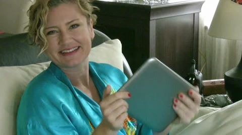 Woman with touch screen tablet computer smiling to camera Video stock 34389162